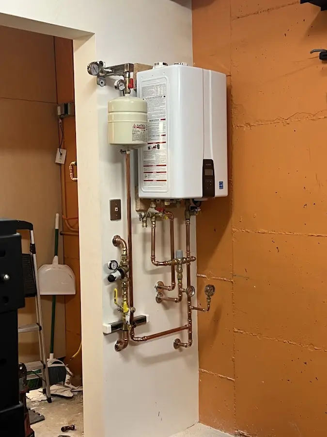 Plumbing technician inspecting water heater connections in Fayetteville